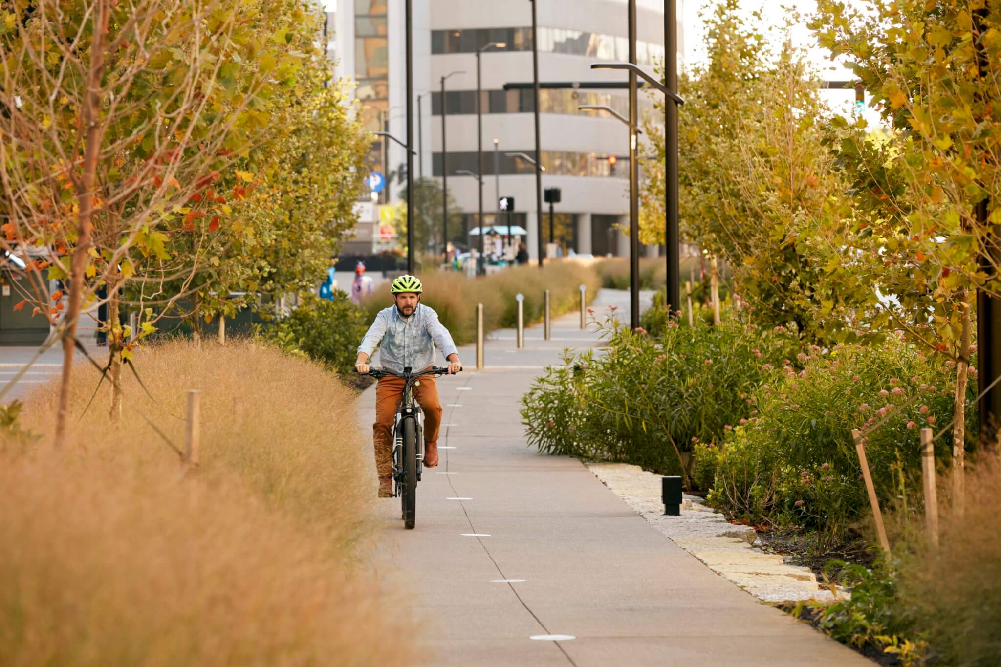a cyclist rides alongs a multiuse trail in a downtown area