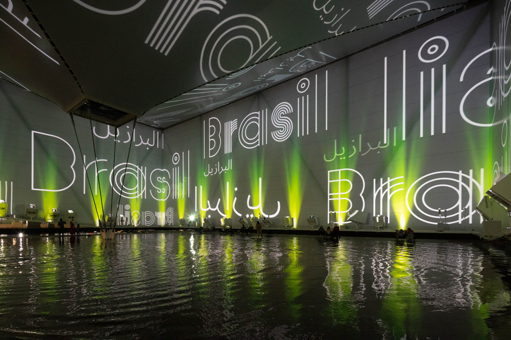 digital projects spelling out "brasil" surround an indoor pool of water