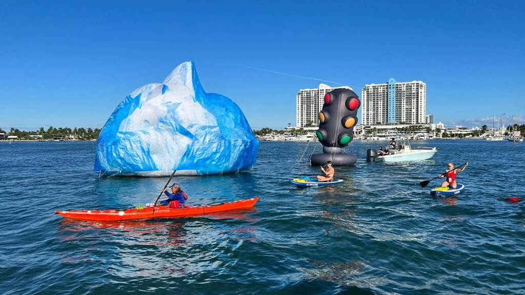 kayakers in miami rowing past inflatable icebergs