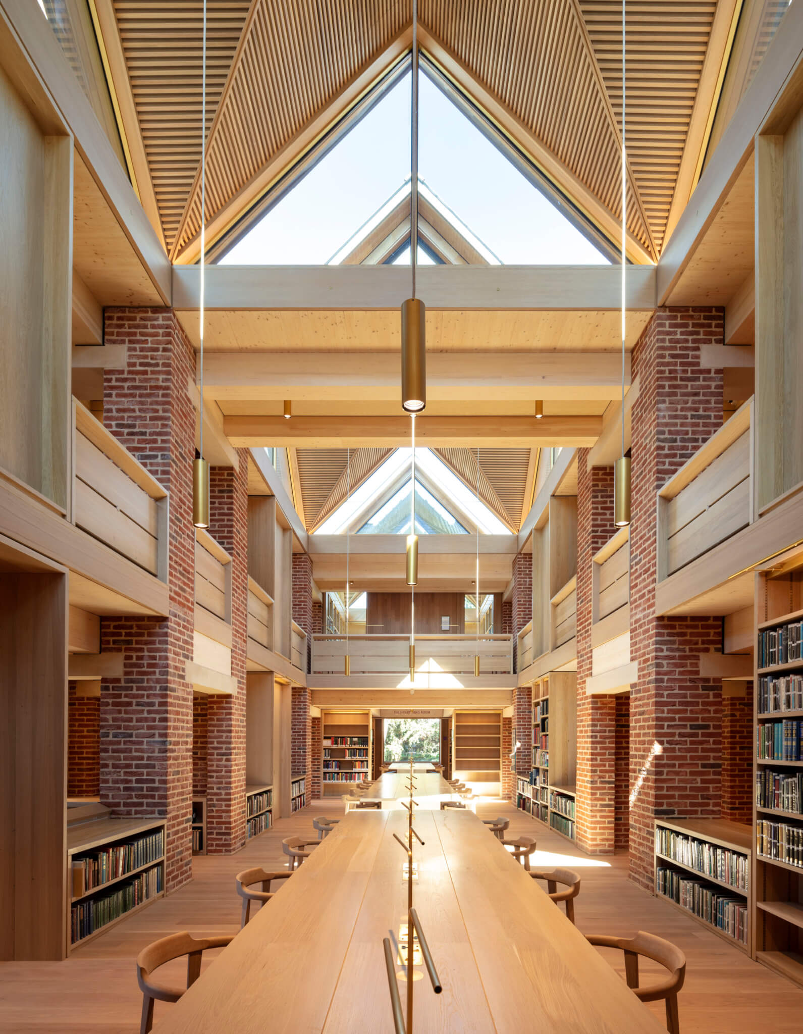 looking down a long library study hall with timber and large windows