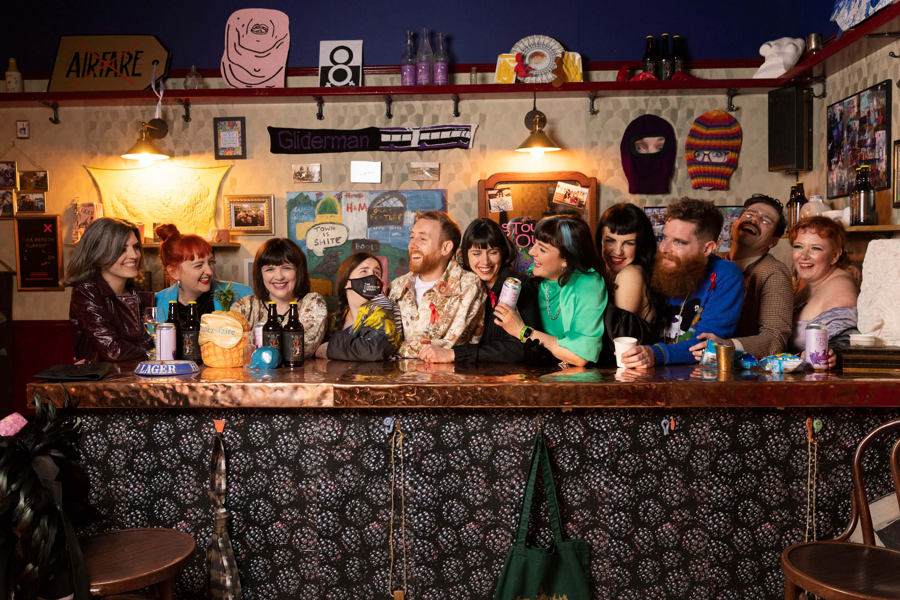 members of an artists collective gather around a bar for a drink, the 2021 turner prize winenrs