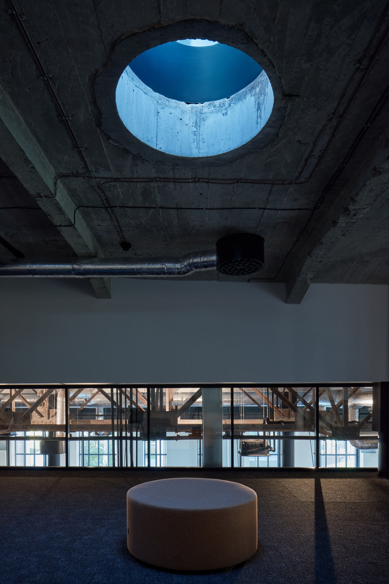 looking at a concrete ceiling with hole for natural light in a base4work office