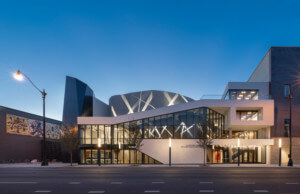The new steppenwolf theater, a sloped glass volume at night