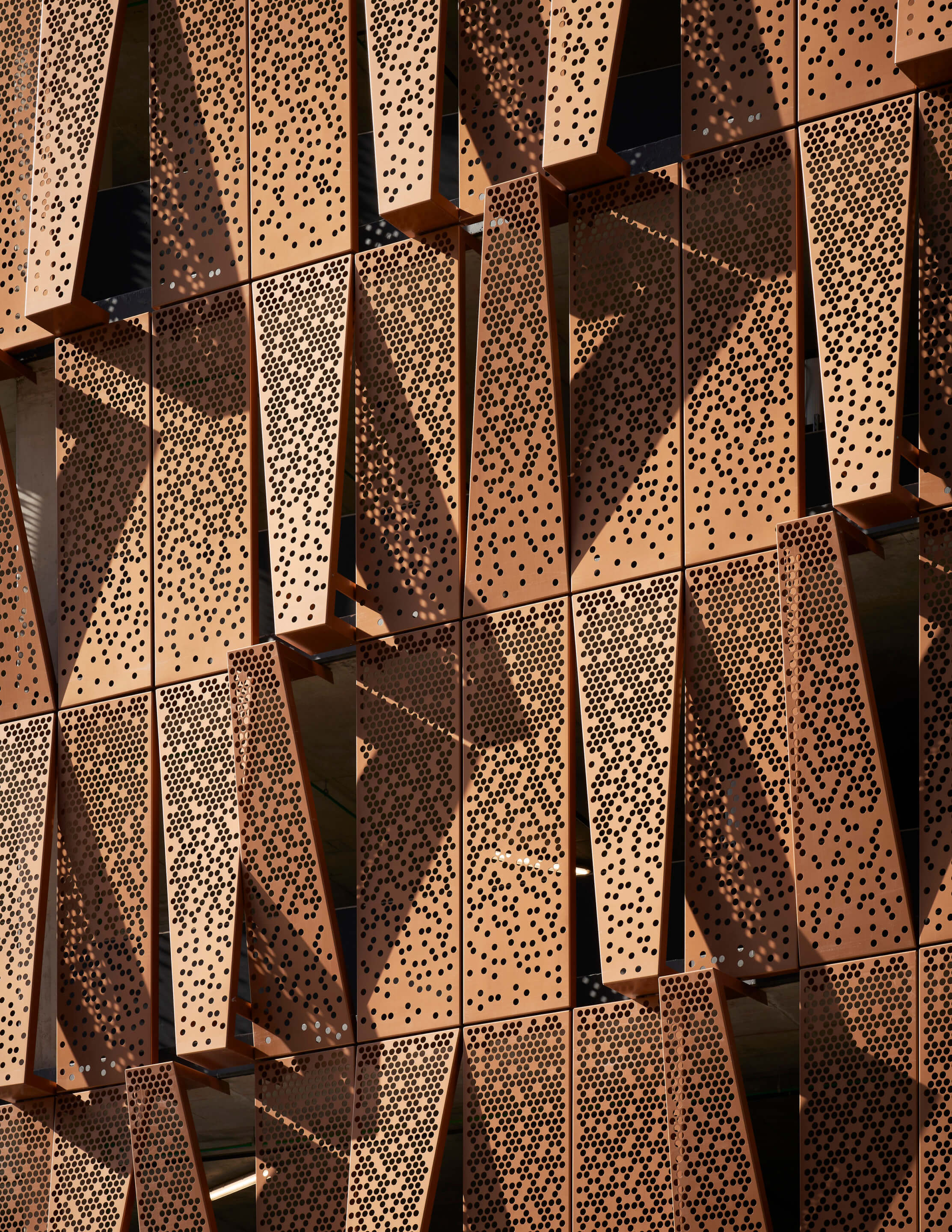 Perforated copper-colored panels with varying hole thicknesses