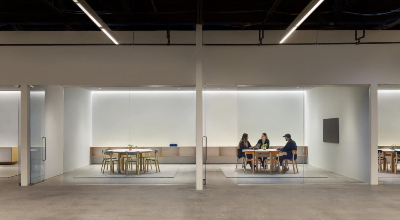 people sit at open offices in a facotry space