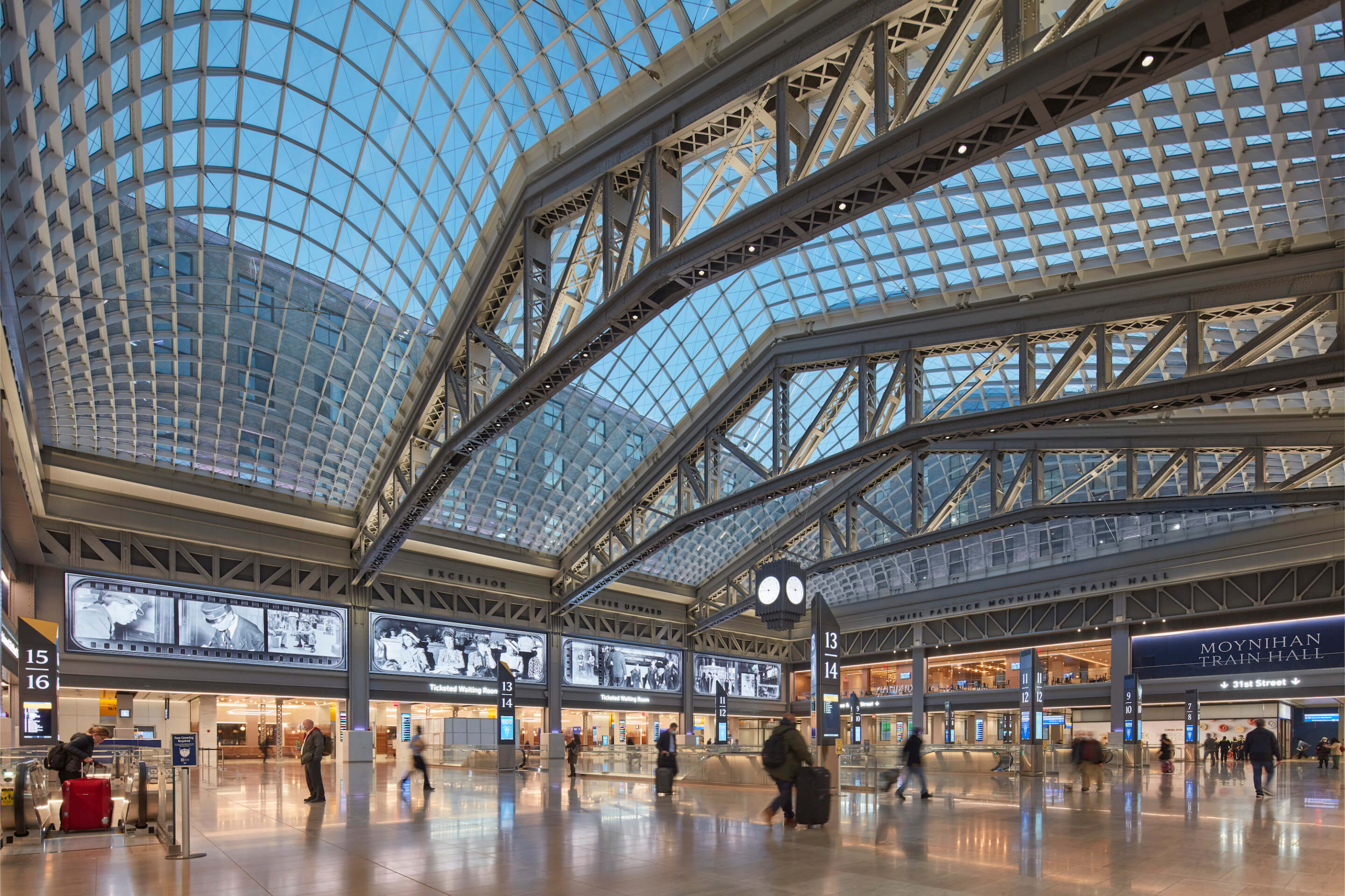 a soaring train hall with a glass ceiling