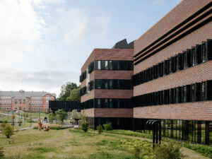 facade of a brick education building surrounded by lush open space