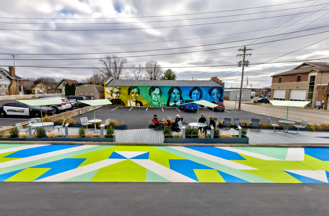 a pocket park in a parking lot featuring a bright asphalt mural