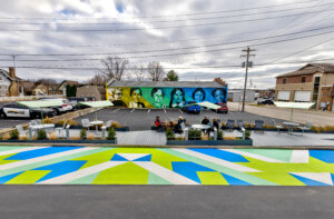 a pocket park in a parking lot featuring a bright asphalt mural