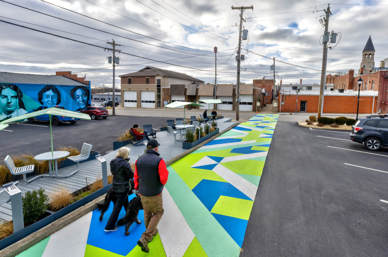 people walk along a pedestrian path/asphalt mural