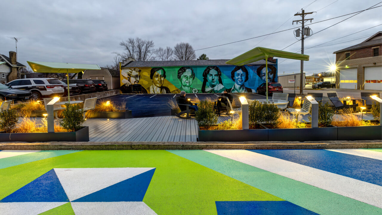 a pocket park parking lot with a colorful asphalt mural in the foreground