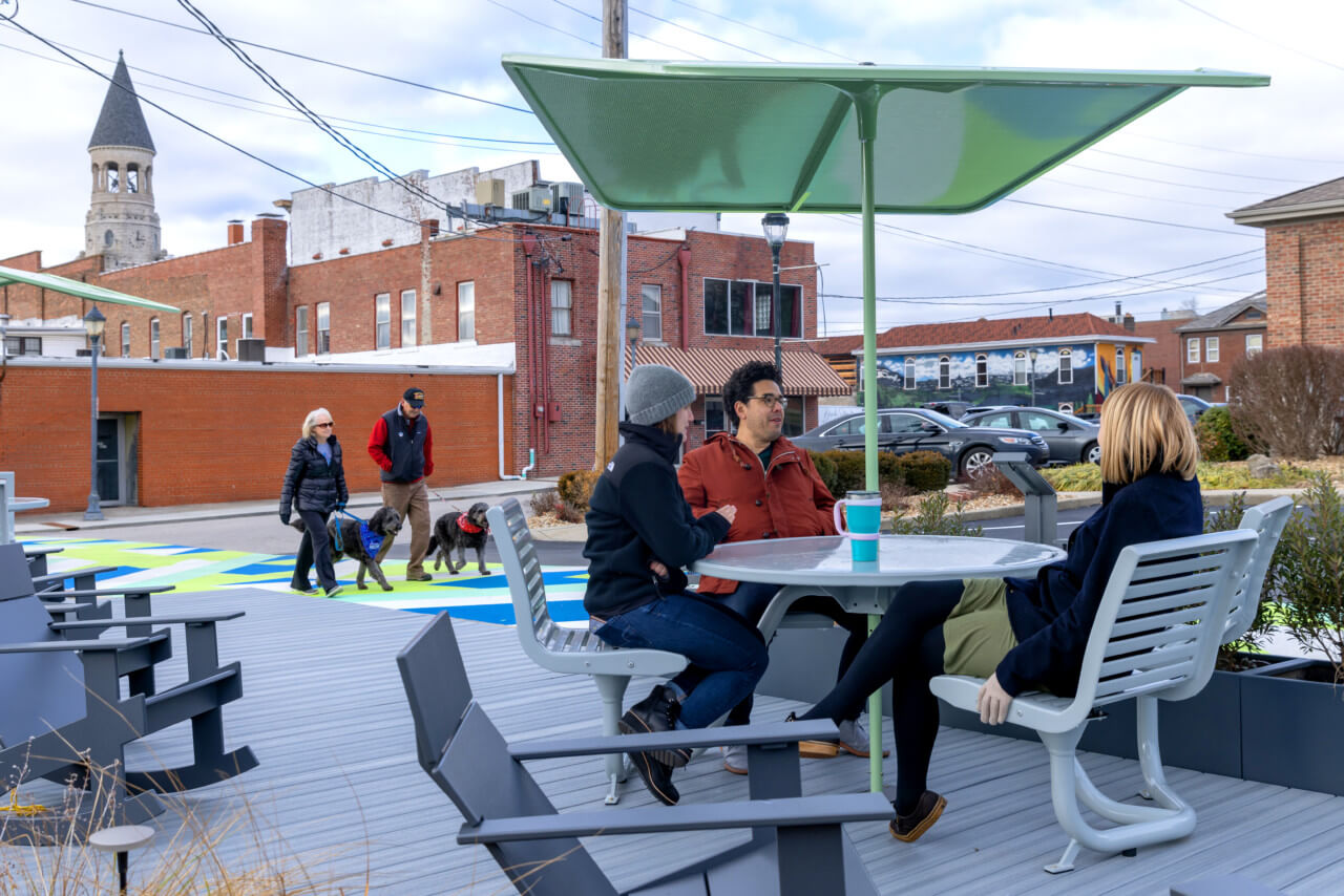 people gather and socialize at a table in a pocket park
