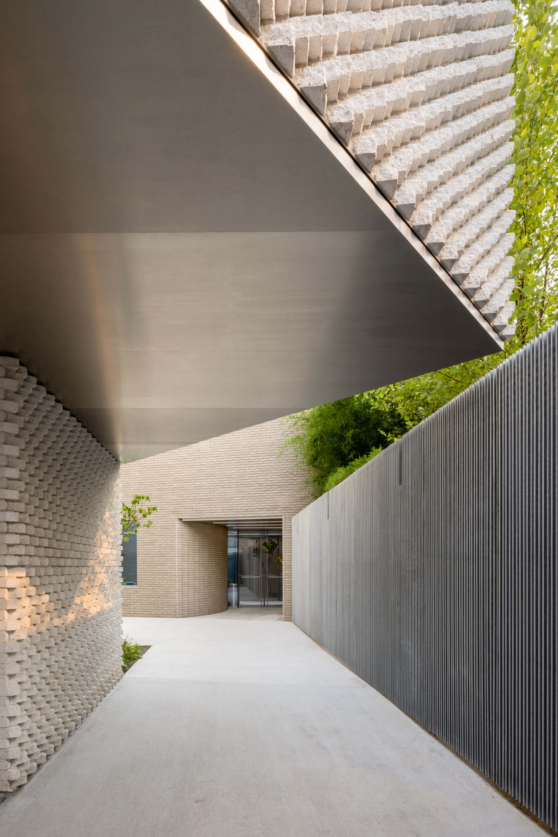 A cantilevering volume clad in tesselating brick at the amant foundation