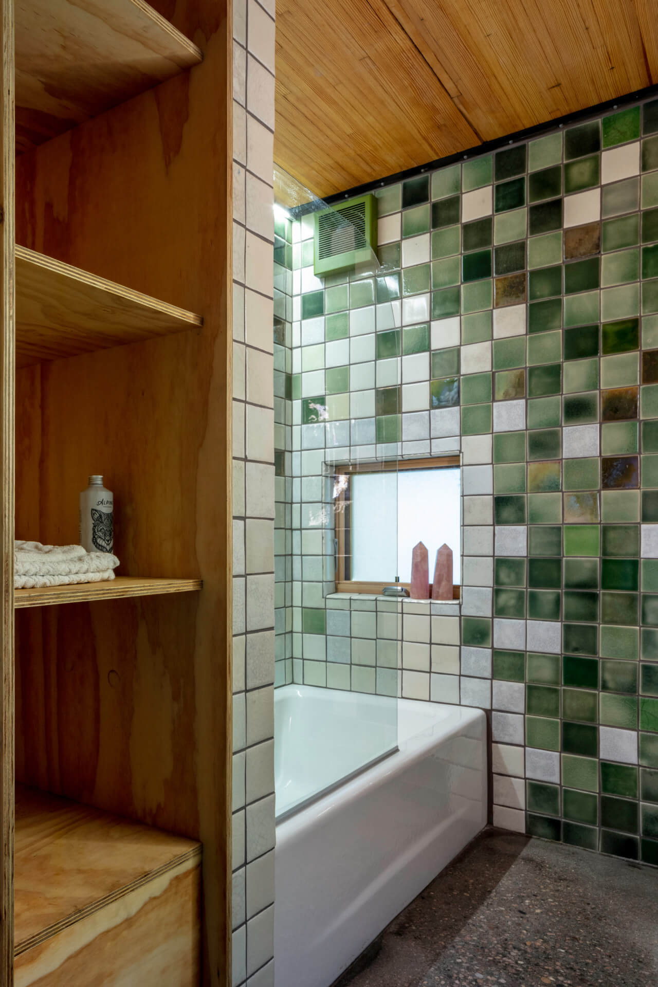 a bathroom wrapped in green tile