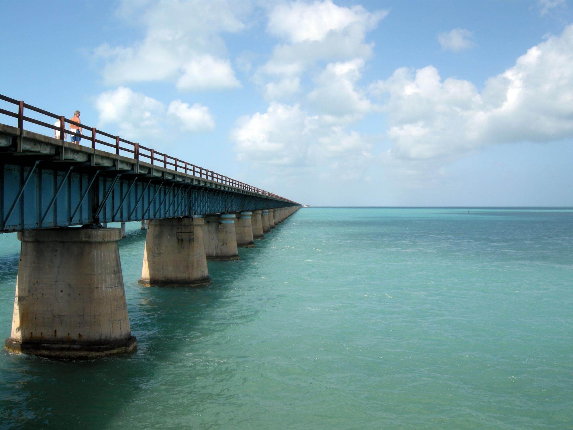 a person standing on an old bridge in the florida keys