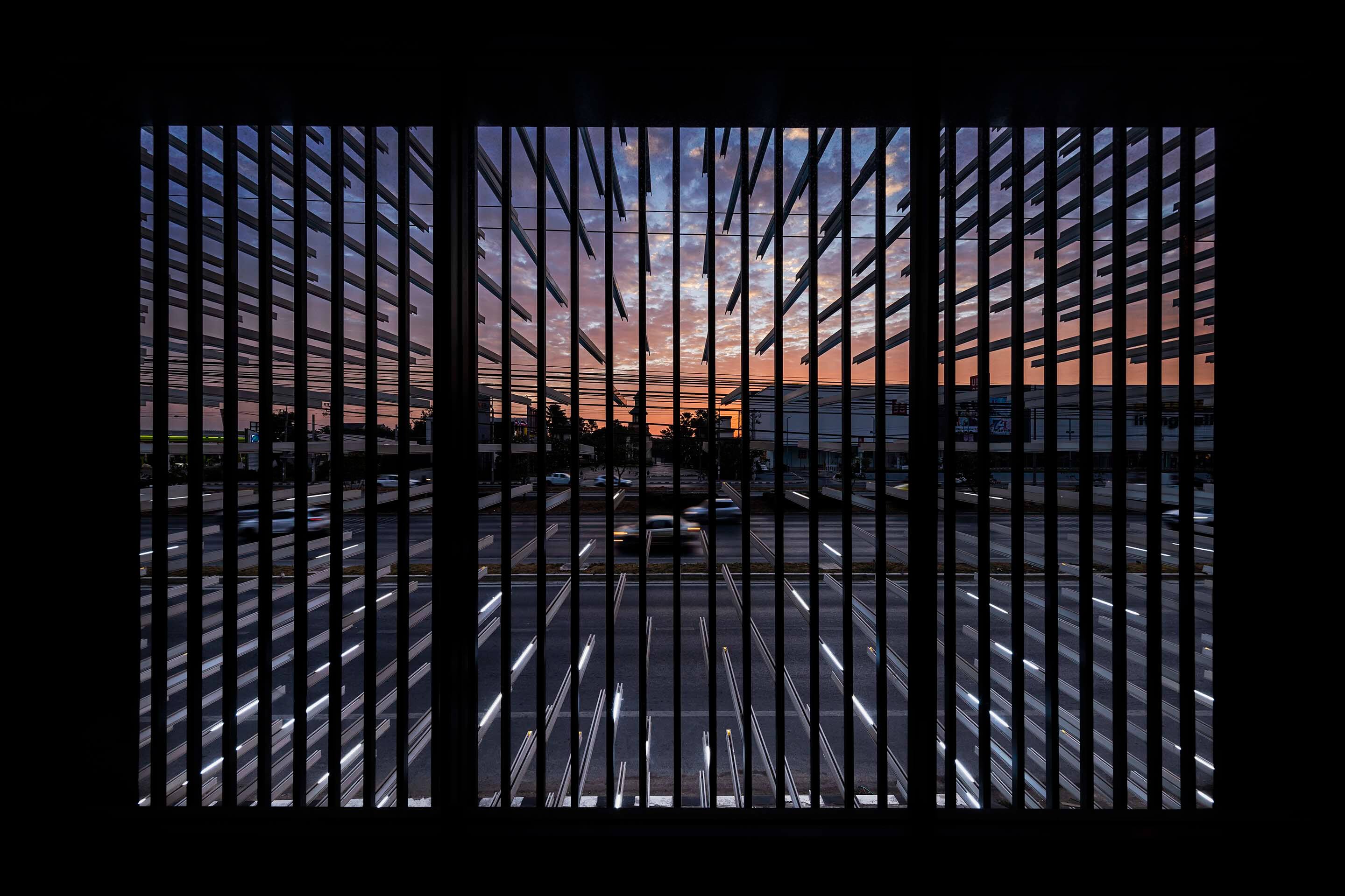 looking out at a parking lot through strips of metal
