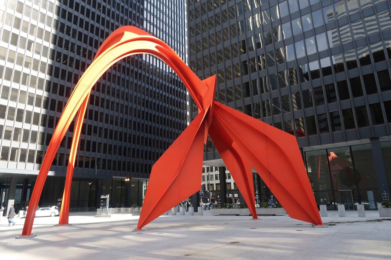 a large red modern sculpture outside a federal office building