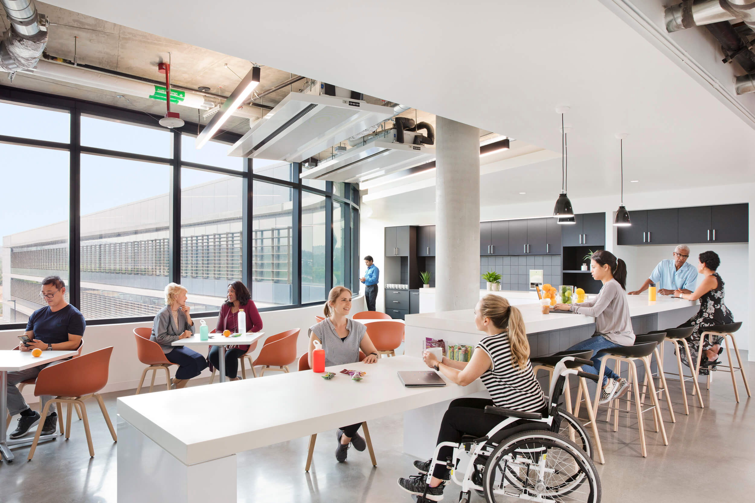 co-workers of all abilities sit and relax in a an employee lounge