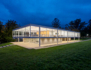 a boxy, glass-encased mies van der-rohe building pictured at night