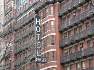 A sign for the chelsea hotel on red brick