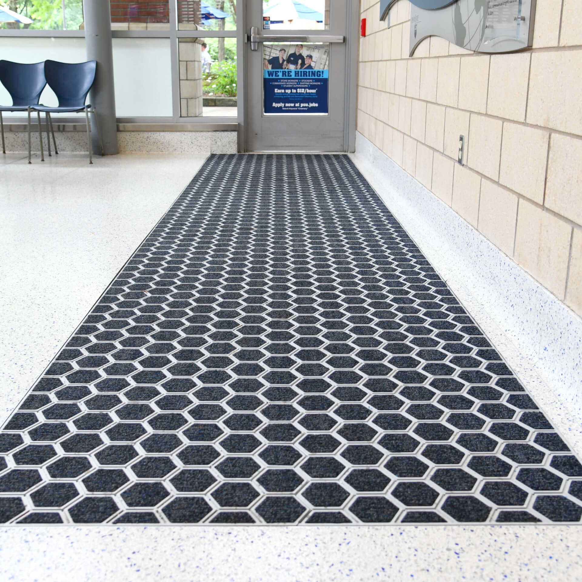 a built-in hexagonal rug at the entrance of a school building