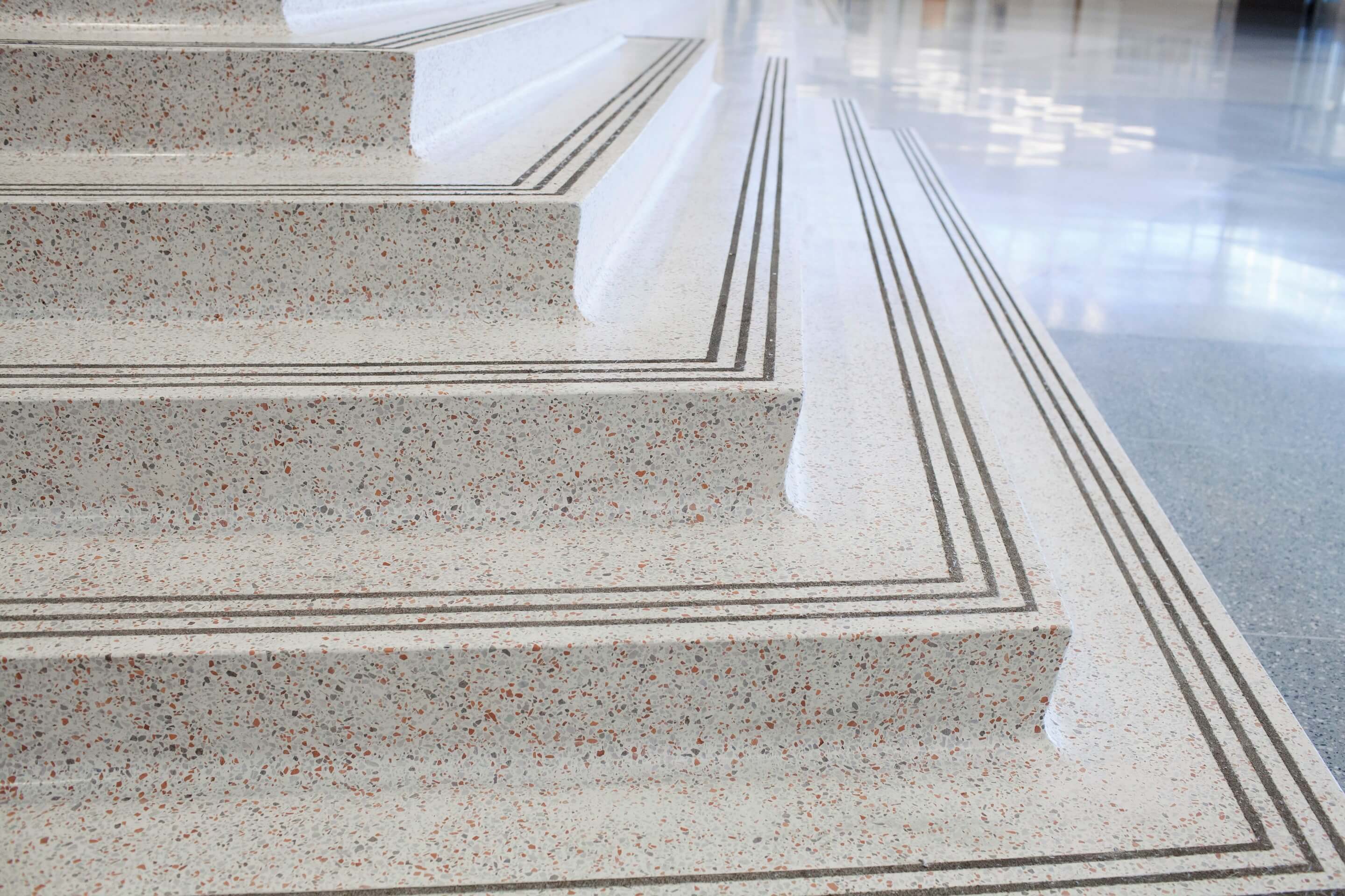 close up of a white corner stair with red speckled aggregate
