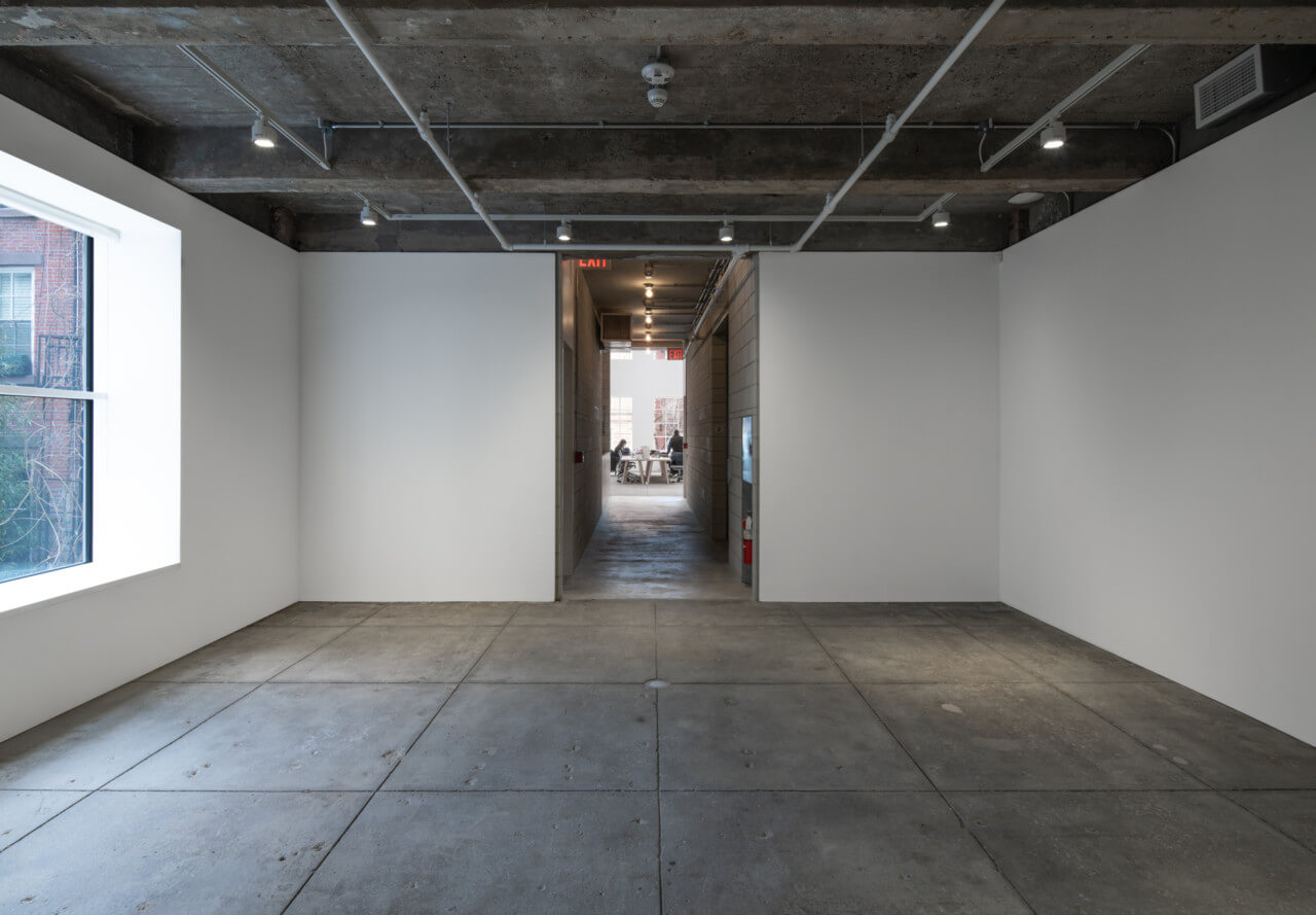 interior of an art space with concrete flooring and ceiling