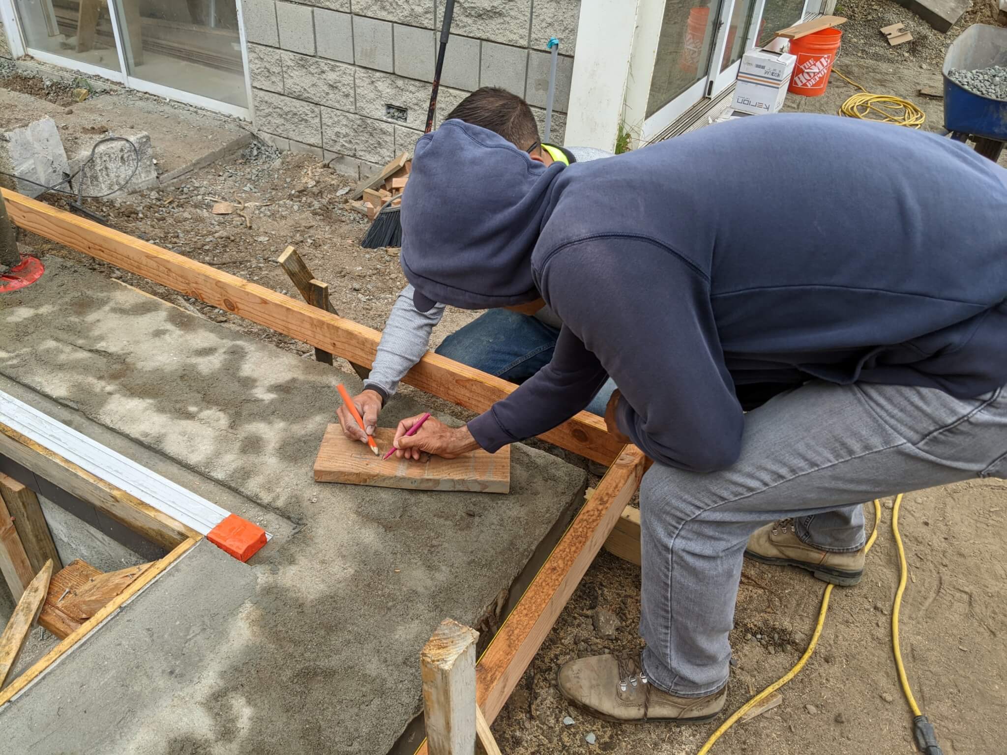 landscape workers taking measurement during a concrete pour