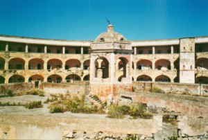 view of the Santo Stefano prison's ruins, everything is worn-down with the watch tower in the middle of the prison's courtyard.