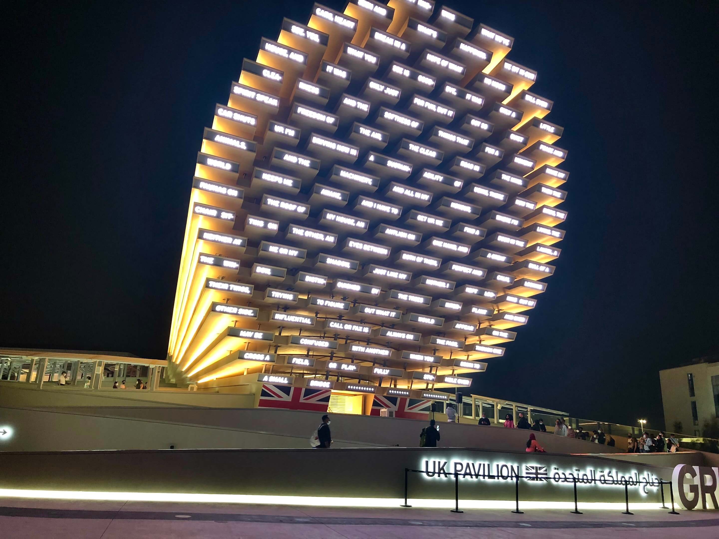 The UK Pavilion features light-up phrases arranged in a large oval atop a plinth.