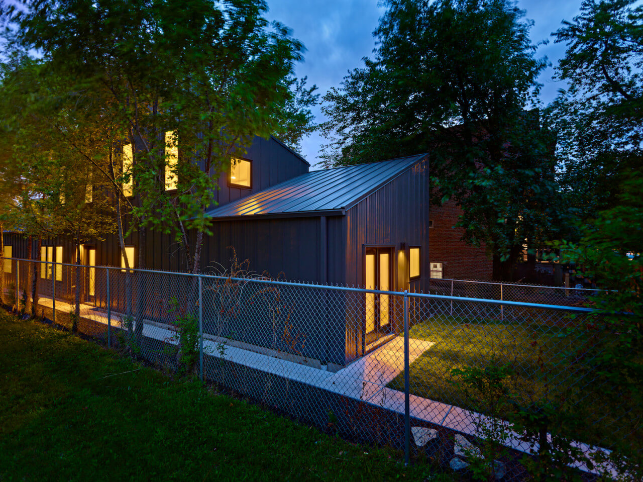 a narrow, metal-clad chicago home pictured at night