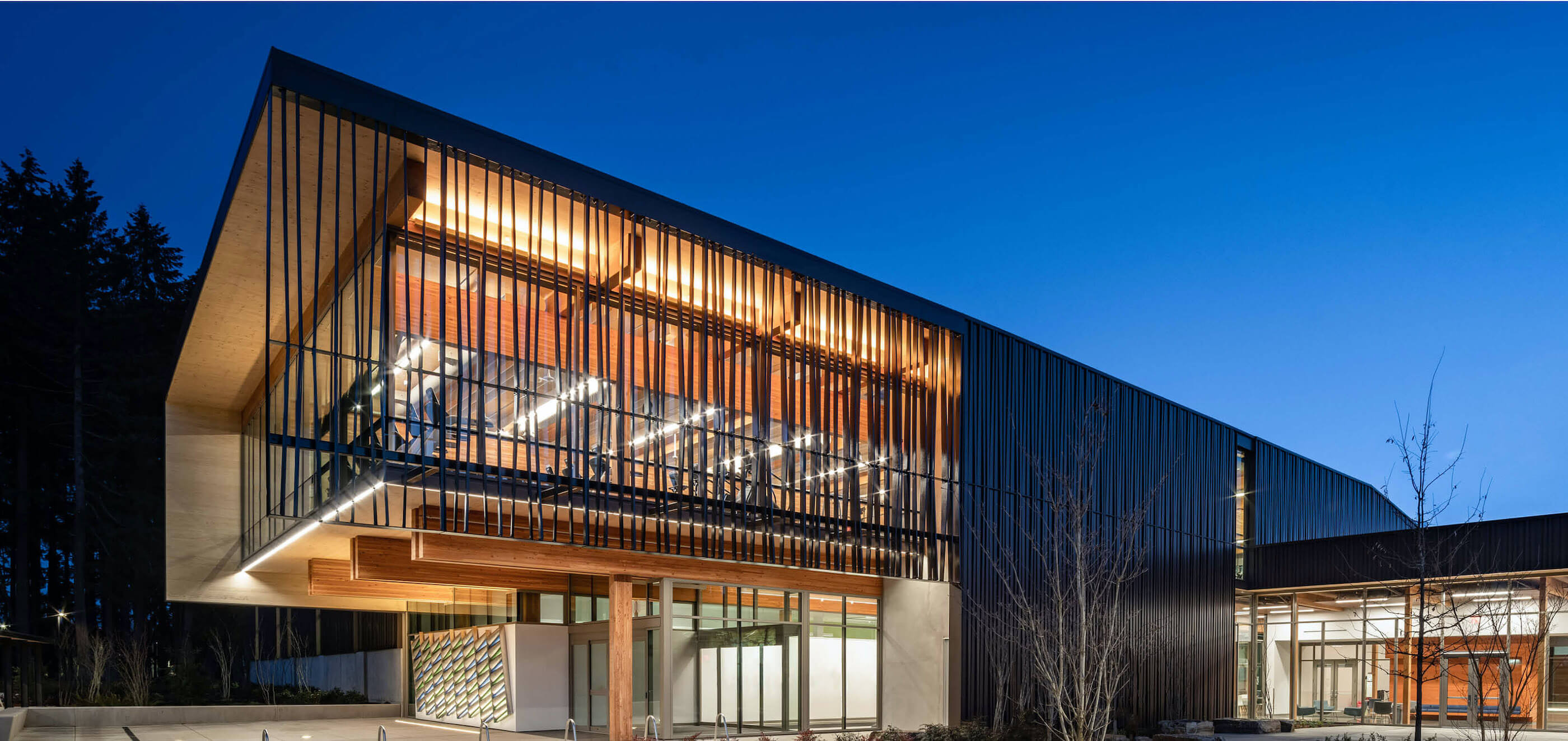 view of a cantilevered mass timber building at night