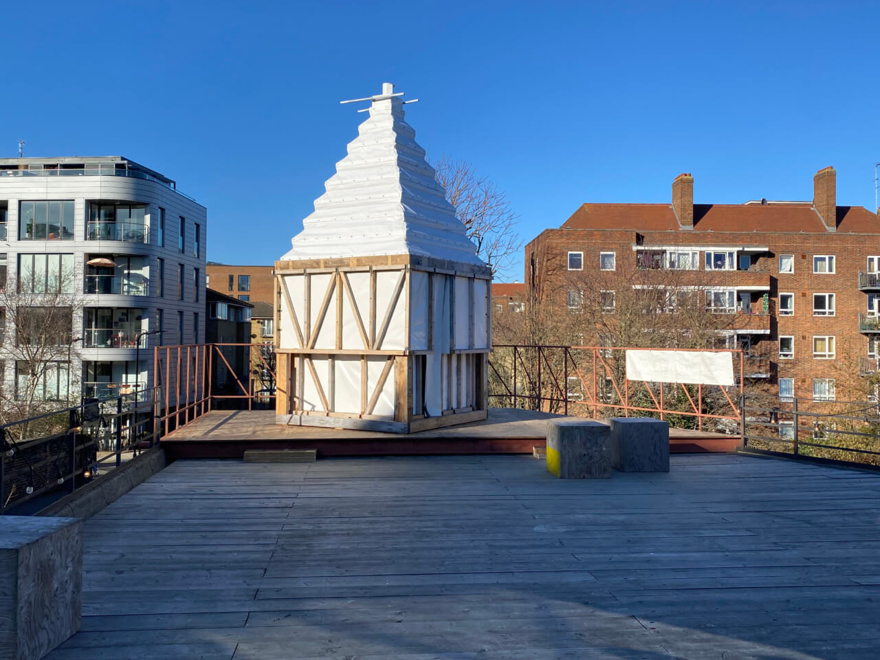 a plain white pyramid on a roof for Antepavilion
