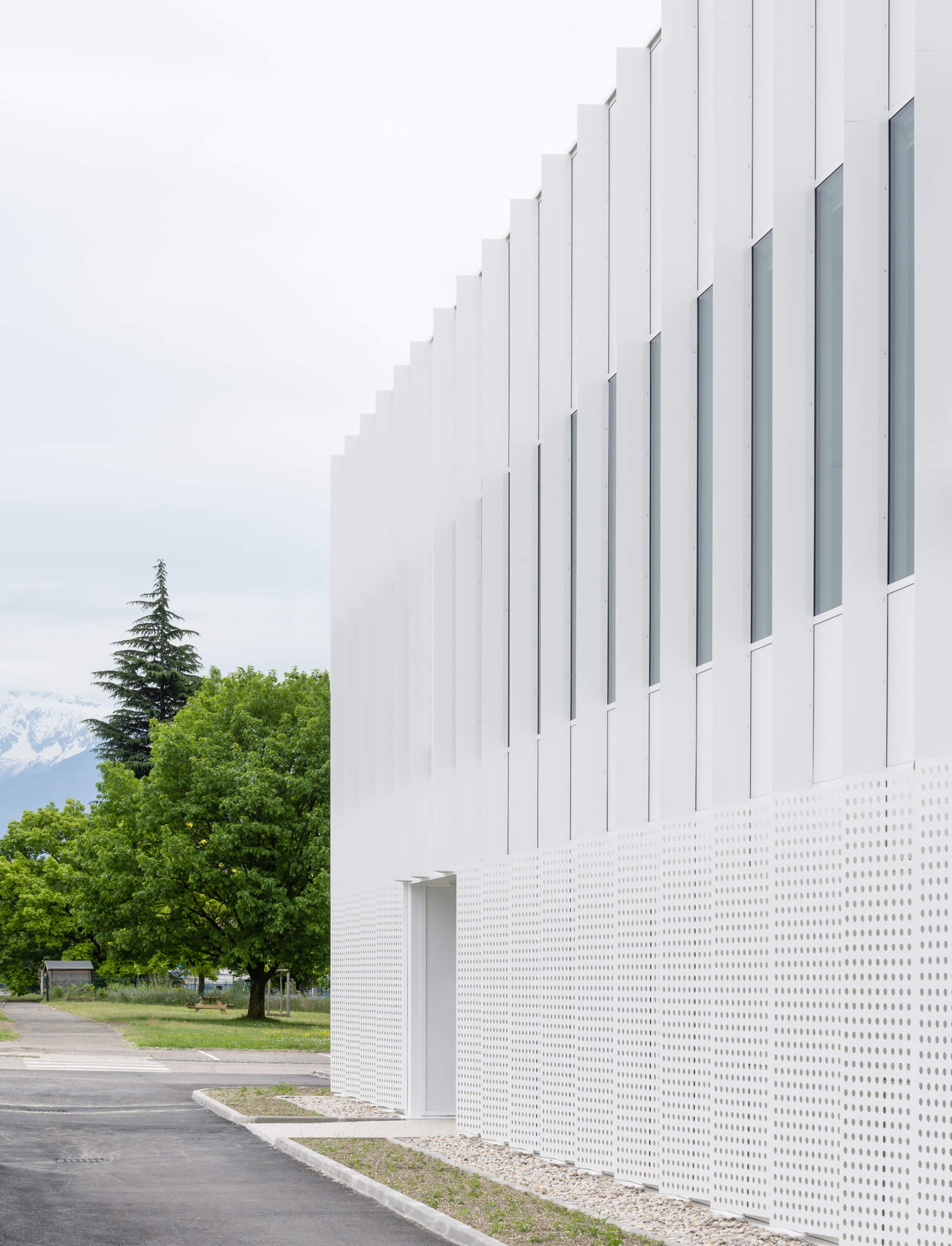 Profile view of a white building with perforated fins