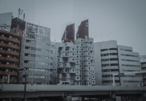 view of a capsule building in tokyo with highway in foreground