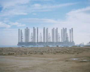 photograph depicting an oil refinery in the distance