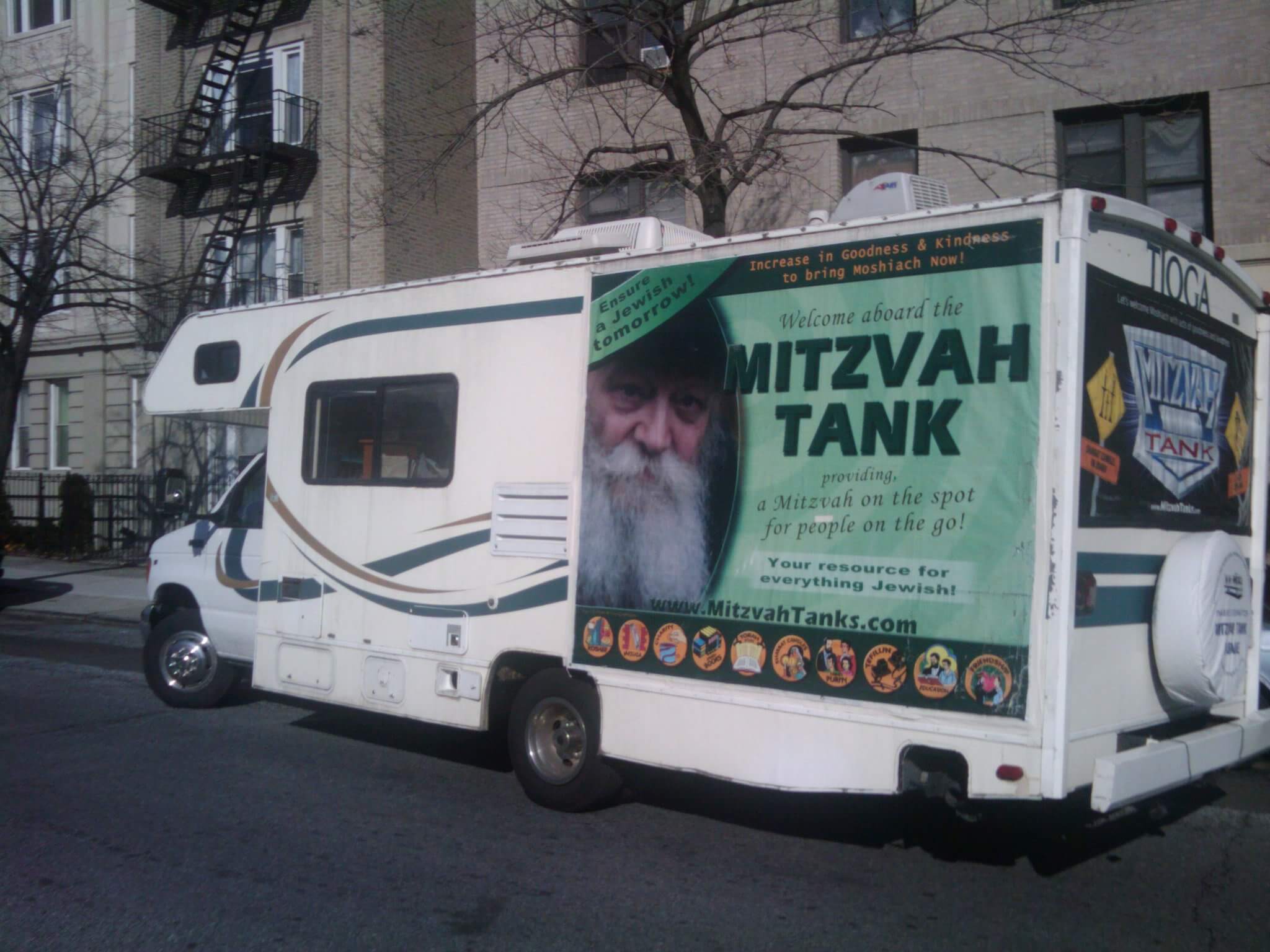 Mitzvah tank with picture of the Rebbe on a green banner