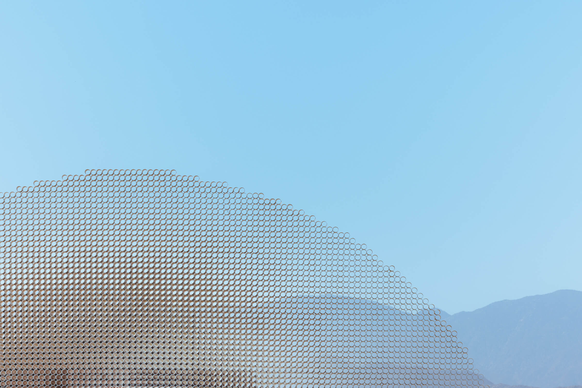 a gridded dome structure rising in the desert