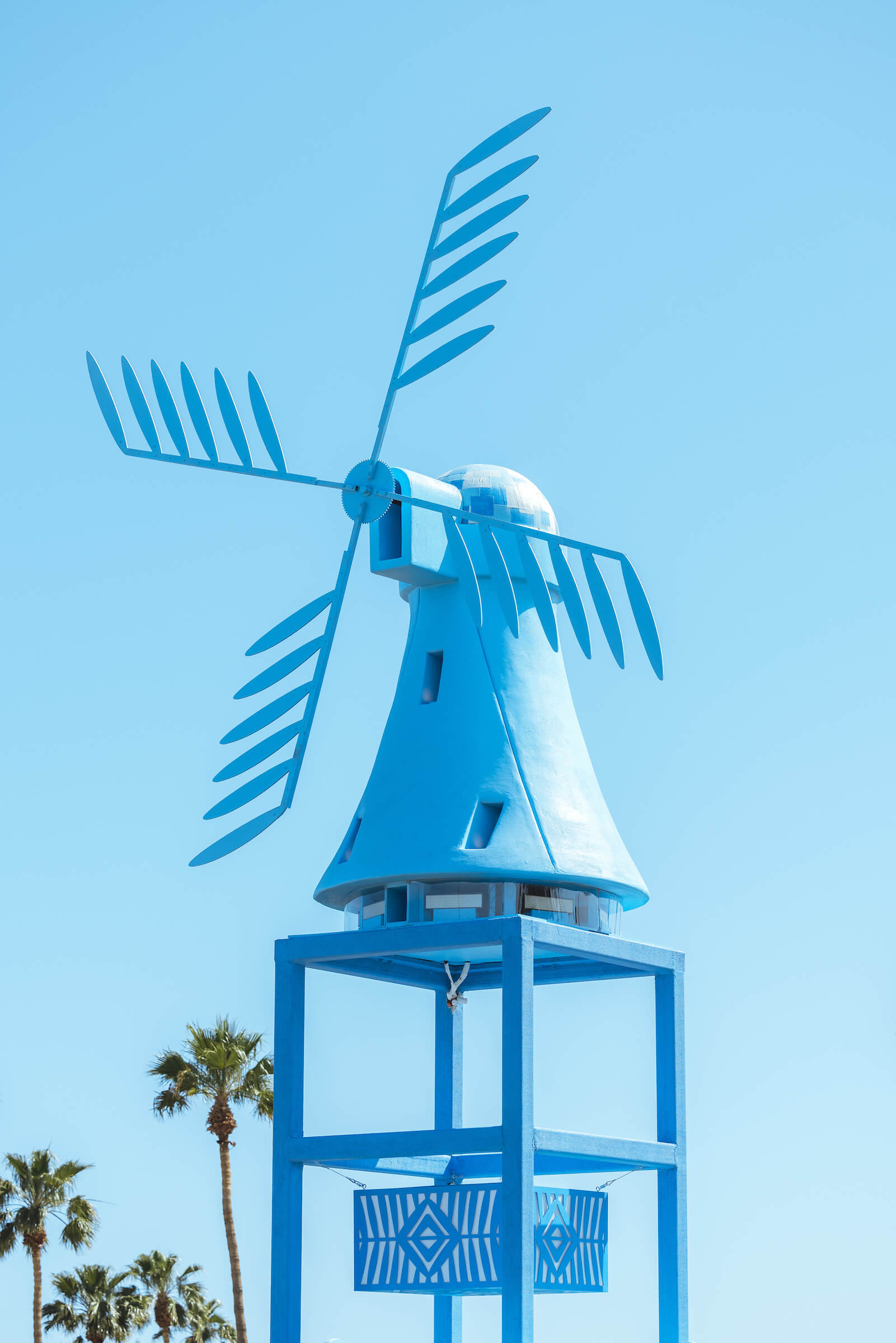 a large blue art installation resembling a traditional dutch windmill