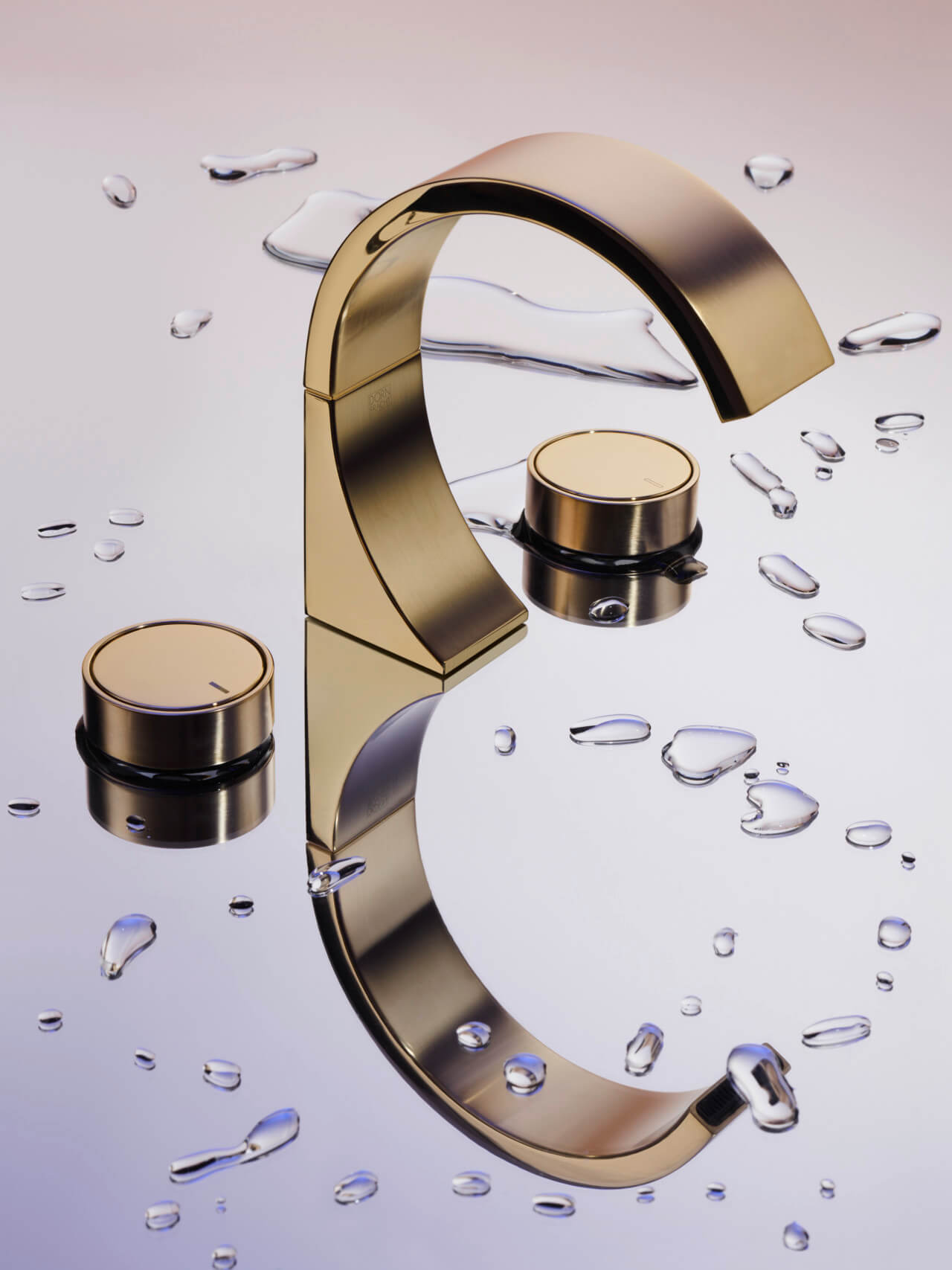 a gold curved faucet and round knobs on a reflective surface