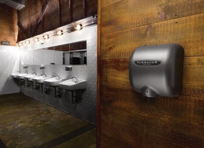 Hand dryer on a wood wall in a public bathroom with 6 sinks