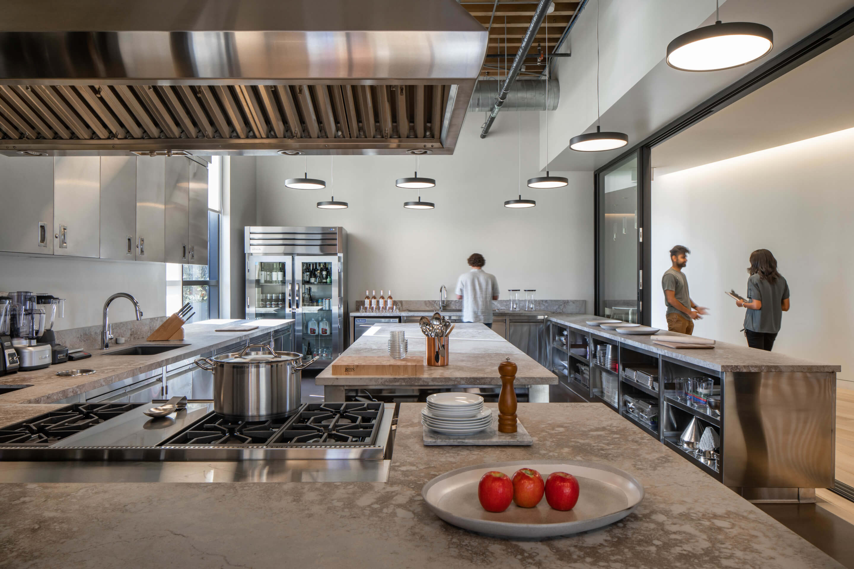 a plate of tomatoes sits inside of a large industrial kitchen