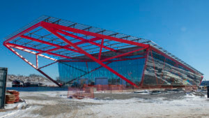 construction photo of a large building with red trusses