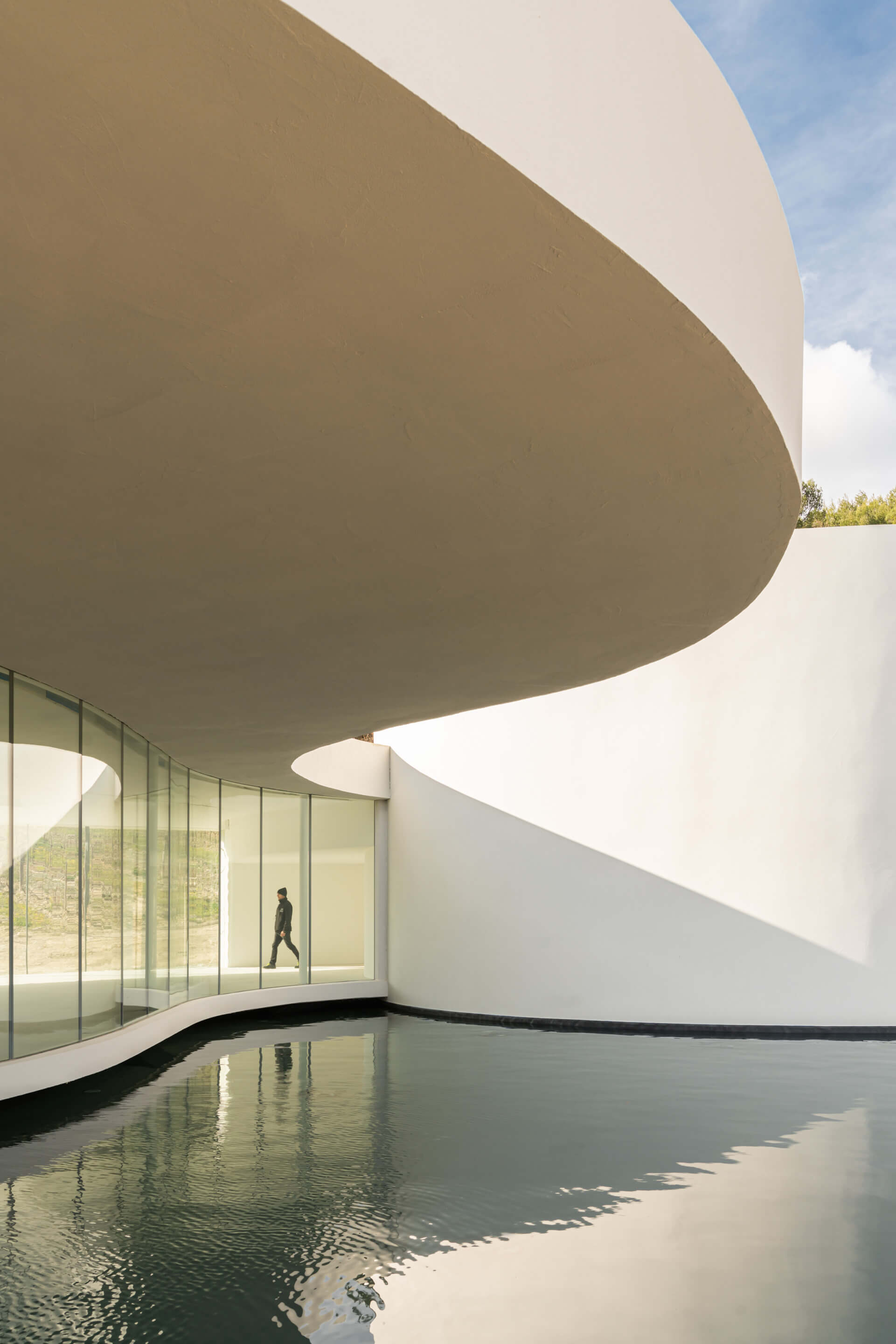 a curvy gallery space and a reflecting pool