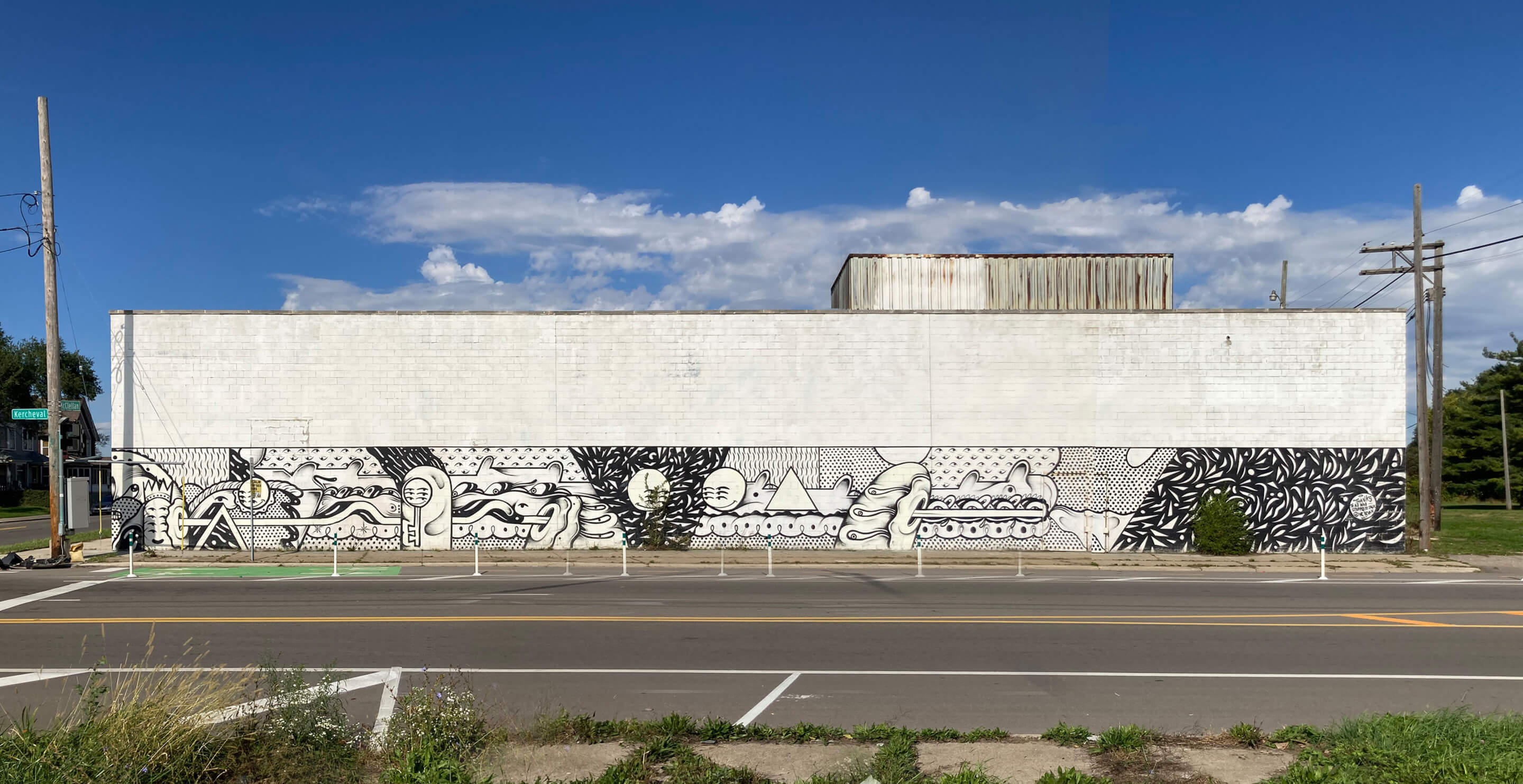 facade of a long warehouse building with concrete walls and graffiti 