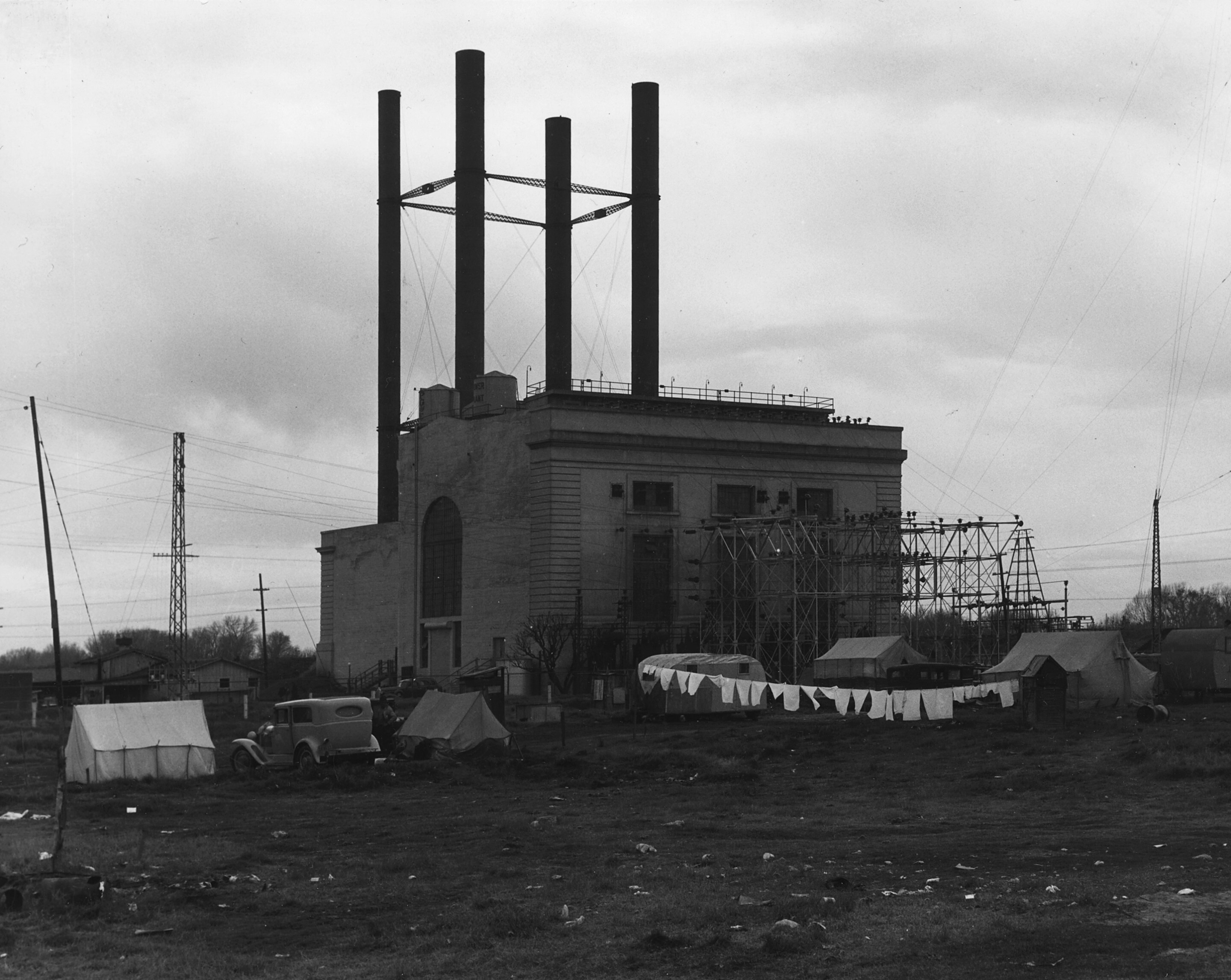 historic photo of an old power station with tents outside