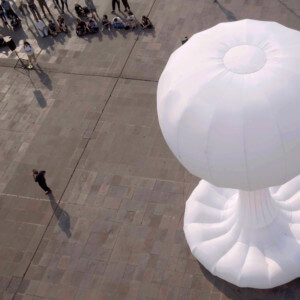 large white inflated sculpture on a plaza