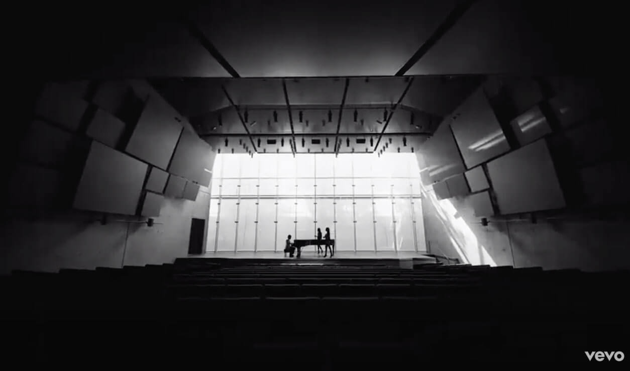 black and white shot of a man at a piano