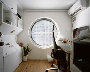 view of a tiny office space and bed with a large circular window