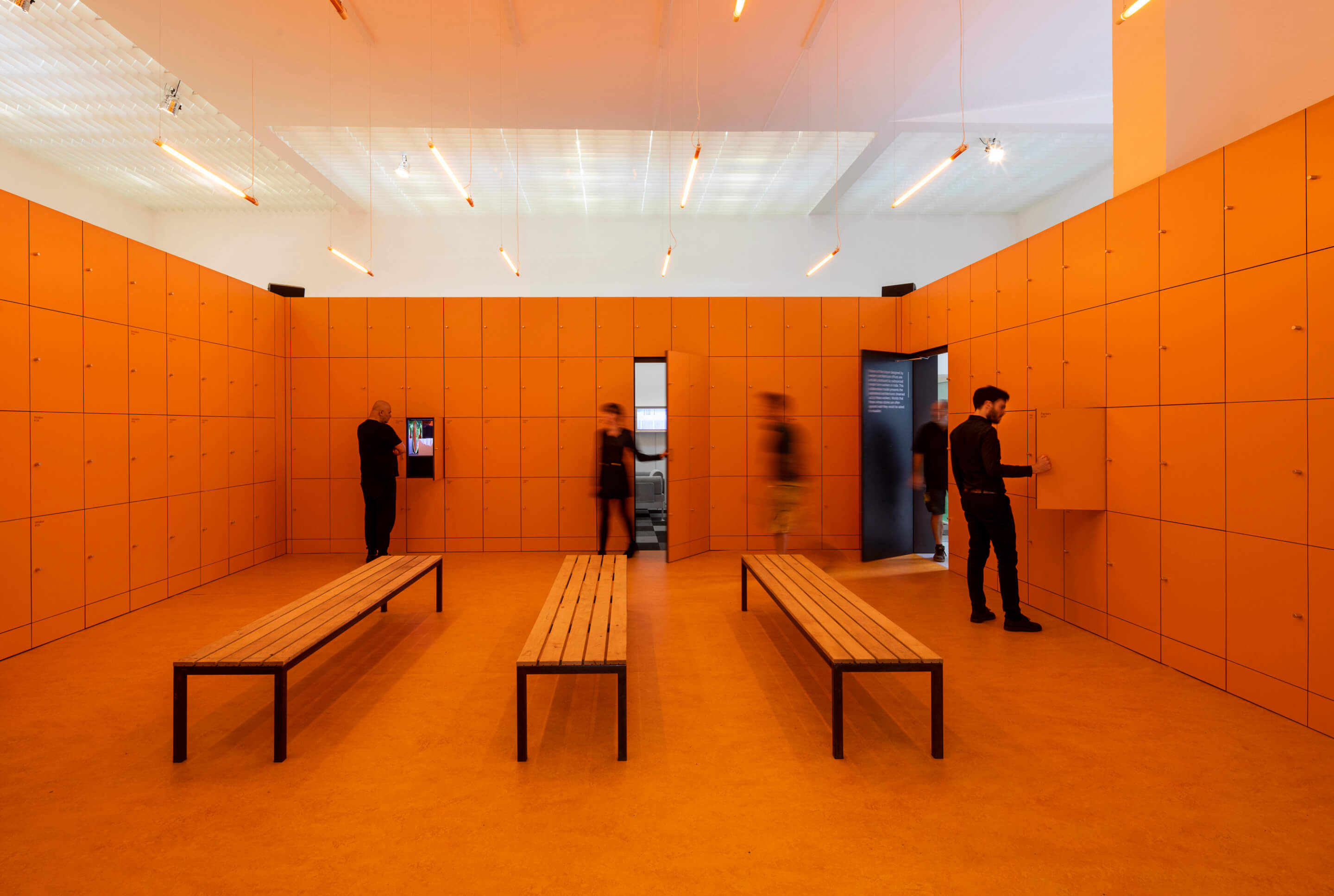 a orange-hued room with three benches 